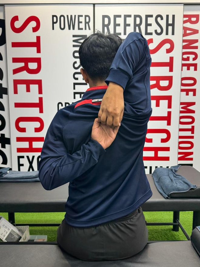 After — hands meet behind the back